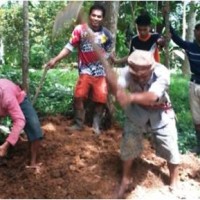 Warga setempat sedang membersihkan longosran yang menutupi jalan.